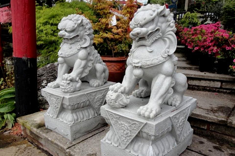 Outdoor Chinese stone lion fu dogs in front of house